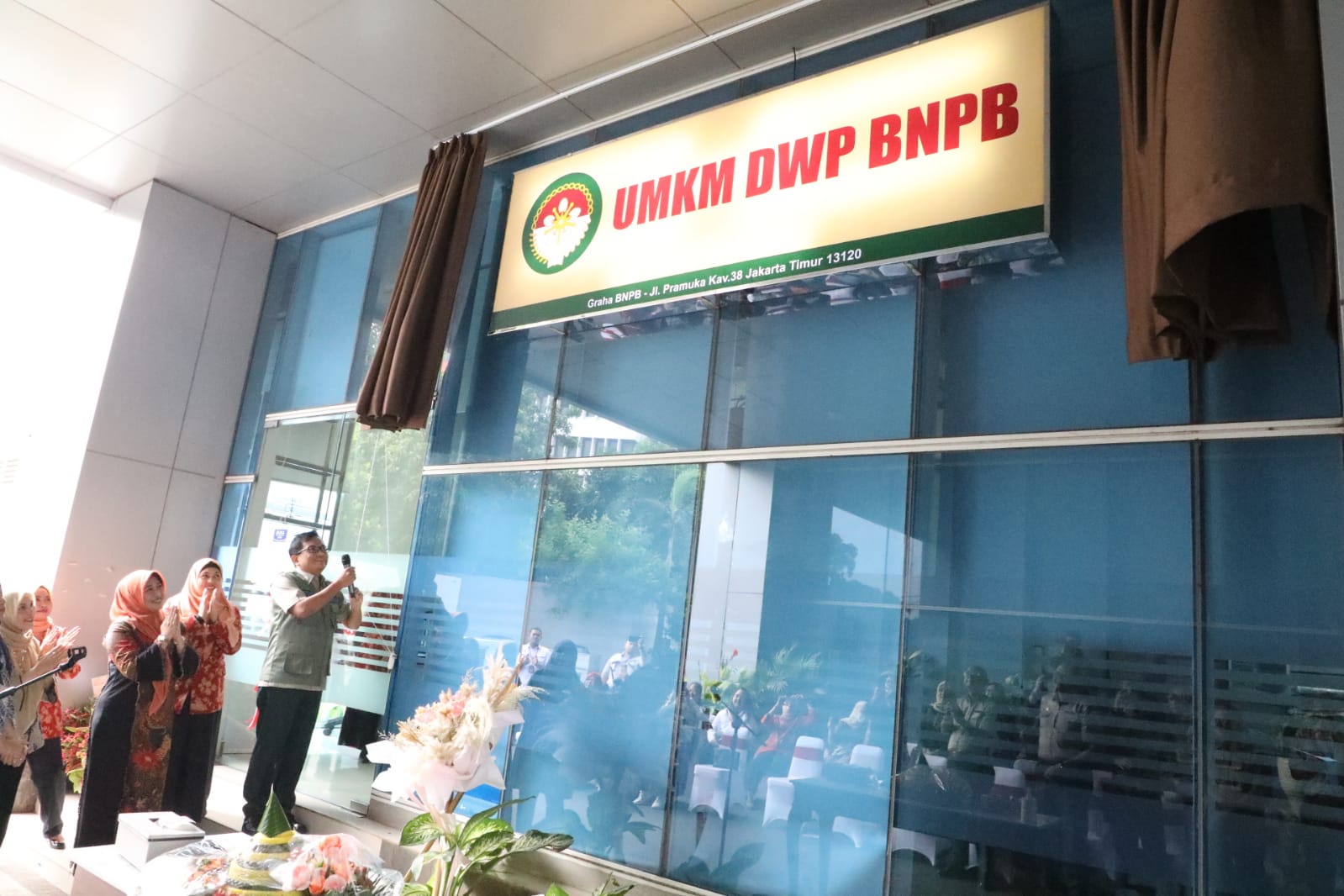Plt Sekretaris Utama BNPB Rustian (rompi hijau) dan Ketua DWP BNPB Uke Suharyanto (baju hitam dengan kerudung orange) meresmikan Toko UMKM DWP BNPB yang bertempat di Lobi Selatan Gedung Graha BNPB Jakarta, pada Kamis (8/6). 